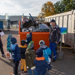 Kinder stehen am Mischschrott-Container
