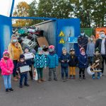 Kinder stehen vor Kleingeräte-Container